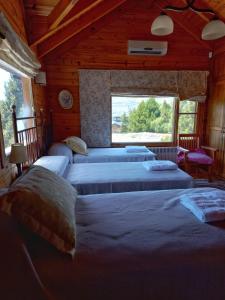 um quarto com 4 camas e uma janela em La Soñada casa de montaña em San Martín de los Andes