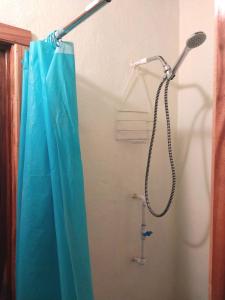 La salle de bains est pourvue d'une douche et d'un rideau de douche bleu. dans l'établissement Cabanas Rusticas, à Las Peñitas