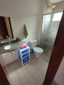 een badkamer met een toilet, een wastafel en een douche bij Chalet no paraíso in Maracajaú