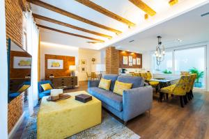 a living room with a blue couch and a dining room at Torres de Serranos Apartments - TTdSSa VLC in Valencia