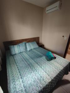 een slaapkamer met een bed met een blauw dekbed bij Chalet no paraíso in Maracajaú