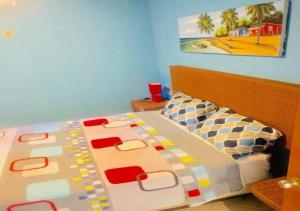 een slaapkamer met een bed met een kleurrijke sprei bij Tamarindo in Bayahibe