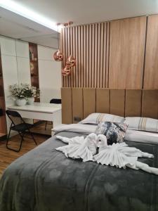 1 dormitorio con 2 muñecas en una cama en Апартамент Мегилукс 2, en Blagoevgrad