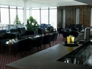 阿什本的住宿－阿什伯恩酒店，一间设有黑色椅子的餐厅和一间酒吧