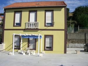 a yellow building with a porch and a blue umbrella at Apartment - 2 Bedrooms - 00119 in Vigo