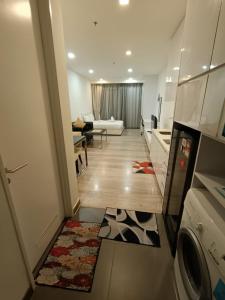 a living room with a kitchen and a living room with a couch at The Perfect Retreat @One Bukit Ceylon (UNIT 25-2) in Kuala Lumpur