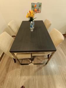 a black dining table with a vase of flowers on it at The Perfect Retreat @One Bukit Ceylon (UNIT 25-2) in Kuala Lumpur