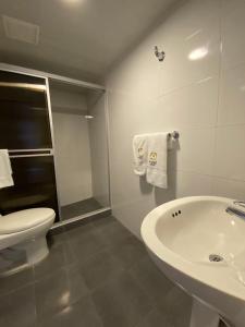 Baño blanco con lavabo y aseo en Hotel Maceo Chico, en Bogotá