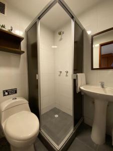 uma casa de banho com um chuveiro, um WC e um lavatório. em Hotel Maceo Chico em Bogotá