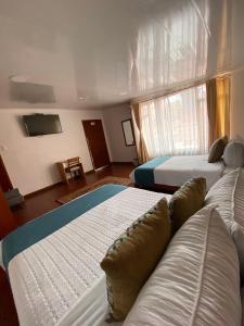 a hotel room with two beds and a pool at Hotel Maceo Chico in Bogotá