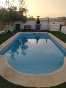 una piscina de agua azul en un patio en Agradable casa con piscina en la serranía. en Arriate