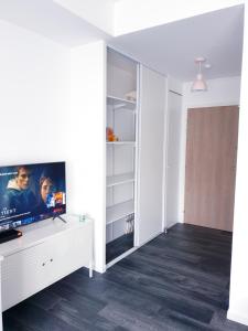 a living room with a tv on a white wall at Appartement studio cosy O fil de l'O à 10 mn de Disney in Crecy la Chapelle
