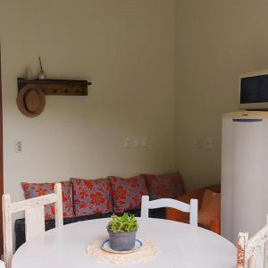 einem weißen Tisch mit einer Topfpflanze darüber in der Unterkunft Apartamento Vila dos Sábias in Florianópolis
