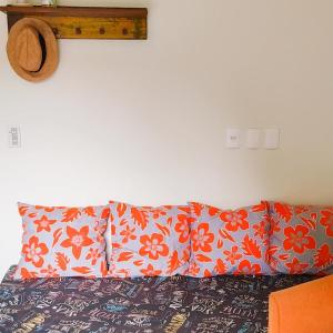 ein Bett mit zwei Kissen und einem Hut an der Wand in der Unterkunft Apartamento Vila dos Sábias in Florianópolis