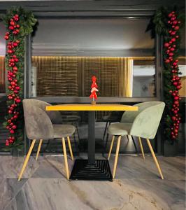 uma mesa de jantar com duas cadeiras e uma figura vermelha no topo em Boutique Villa Isabelle em Predeal