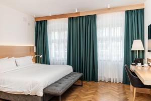 a hotel room with a bed and a desk with a desk at Hotel Casa Luxemburg in Sibiu
