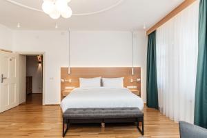a bedroom with a large bed and a couch at Hotel Casa Luxemburg in Sibiu