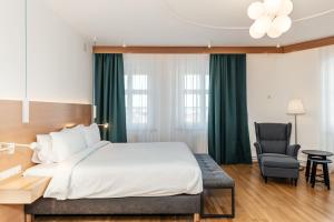 Habitación de hotel con cama y silla en Hotel Casa Luxemburg- Newly Renovated, en Sibiu