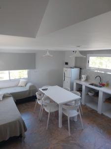 a white kitchen with a table and a bed at Altos del Monte in Villa Rumipal