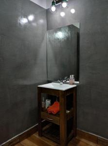 Casa de Toto 3 habitaciones في بويرتو إجوازو: حمام مع حوض ومرآة