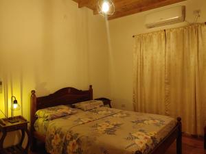 um quarto com uma cama, um candeeiro e uma janela em Casa de Toto 3 habitaciones em Puerto Iguazú