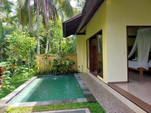 德格拉朗Dukuh Village Villas & Art的庭院中带游泳池的房子