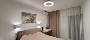塞薩羅尼基的住宿－Thessaloniki Harmony Life apartment，卧室配有一张床,墙上挂有绘画作品