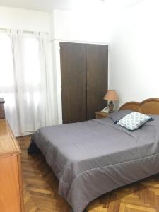 1 dormitorio con 1 cama grande y cabecero de madera en JUNIN APPARTEMENT TWO en Buenos Aires