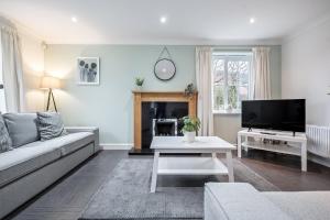a living room with a couch and a tv at Comfortable House close to Junction 15 of M1 in Northampton