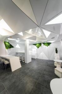 una oficina con paredes blancas y un techo con luces. en Optimi Rooms Madrid en Madrid
