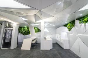 Habitación blanca con plantas en las paredes en Optimi Rooms Madrid en Madrid