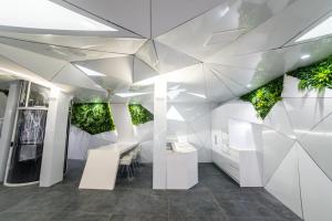 une chambre blanche avec des plantes sur les murs dans l'établissement Optimi Rooms Madrid, à Madrid