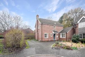 a brick house with a driveway in front of it at Comfortable House close to Junction 15 of M1 in Northampton