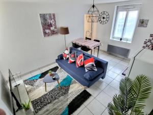 uma sala de estar com um sofá azul e uma mesa em Superbe Type 2 - Cosy et Chaleureux em Bouguenais