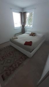 a white bedroom with a bed with a window at Lovely 3 Bedroom Apt. in Maloja