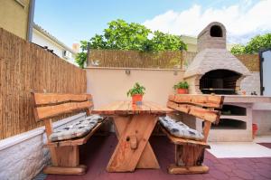 a patio with two benches and a pizza oven at Apartmani Podest in Baška Voda