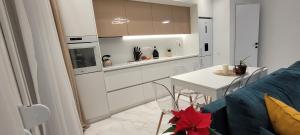 Una cocina con gabinetes blancos y una mesa y un sofá. en Thessaloniki Harmony Life apartment, en Tesalónica 15 fotos más