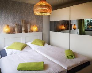 um quarto com 2 camas e almofadas verdes em Ferienhaus IRENE em Meschede