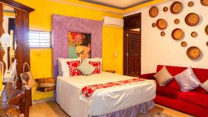 a bedroom with a bed and a red couch at Casa Jaguar Hotel & Boutique in Acapulco