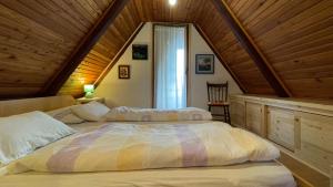 2 bedden in een slaapkamer met een houten plafond bij Holiday home Bozica in Lokve