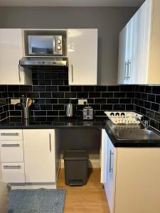 eine Küche mit einer Spüle und einer Mikrowelle in der Unterkunft Somerton Studio in London