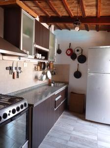 eine Küche mit einem weißen Kühlschrank und einem Herd in der Unterkunft Hermosa casa con parque in Cordoba