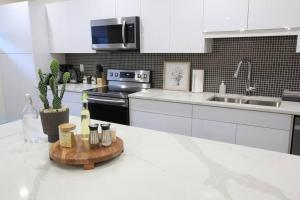 a kitchen with white cabinets and a counter with bottles of wine at Executive Bsmt Suite, King Bed, 5 min to DT & Whyte Ave, Sleeps 6! in Edmonton
