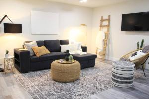 a living room with a couch and a table at Executive Bsmt Suite, King Bed, 5 min to DT & Whyte Ave, Sleeps 6! in Edmonton