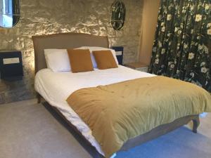a bedroom with a bed with white sheets and brown pillows at River View in Buxton