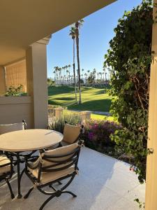 um pátio com uma mesa e cadeiras e um campo de golfe em Palm Paradise em Palm Desert