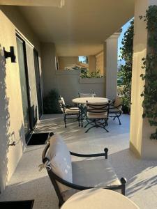 un patio con mesa y sillas en un porche en Palm Paradise, en Palm Desert