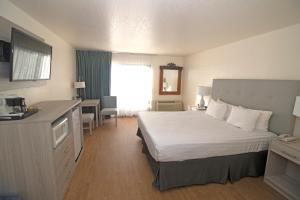 a hotel room with a large bed and a desk at La Serena Inn in Morro Bay