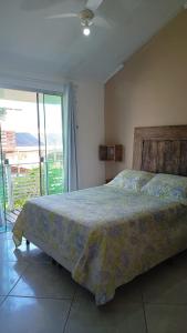 1 dormitorio con 1 cama y puerta corredera de cristal en Casa Samauma Aluguel de Quartos en Florianópolis