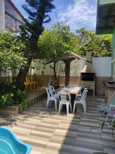 un patio con mesa, sillas y sombrilla en Casa Samauma Aluguel de Quartos en Florianópolis